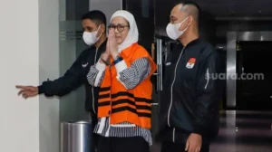 Tersangka mantan Direktur Utama (Dirut) Pertamina Karen Agustiawan (tengah) mengenakan baju tahanan saat dihadirkan dalam konferensi pers pengumuman penahanan tersangka di Gedung Merah Putih KPK, Jakarta, Selasa (19/9/2023). [Suara.com/Alfian Winanto]