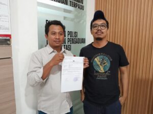 Moeso Novianto (kiri) didampingi Ketua AJI Balikpapan, Erik Alfian saat membuat laporan di SPKT Polresta Balikpapan, Rabu (19/3/2025).