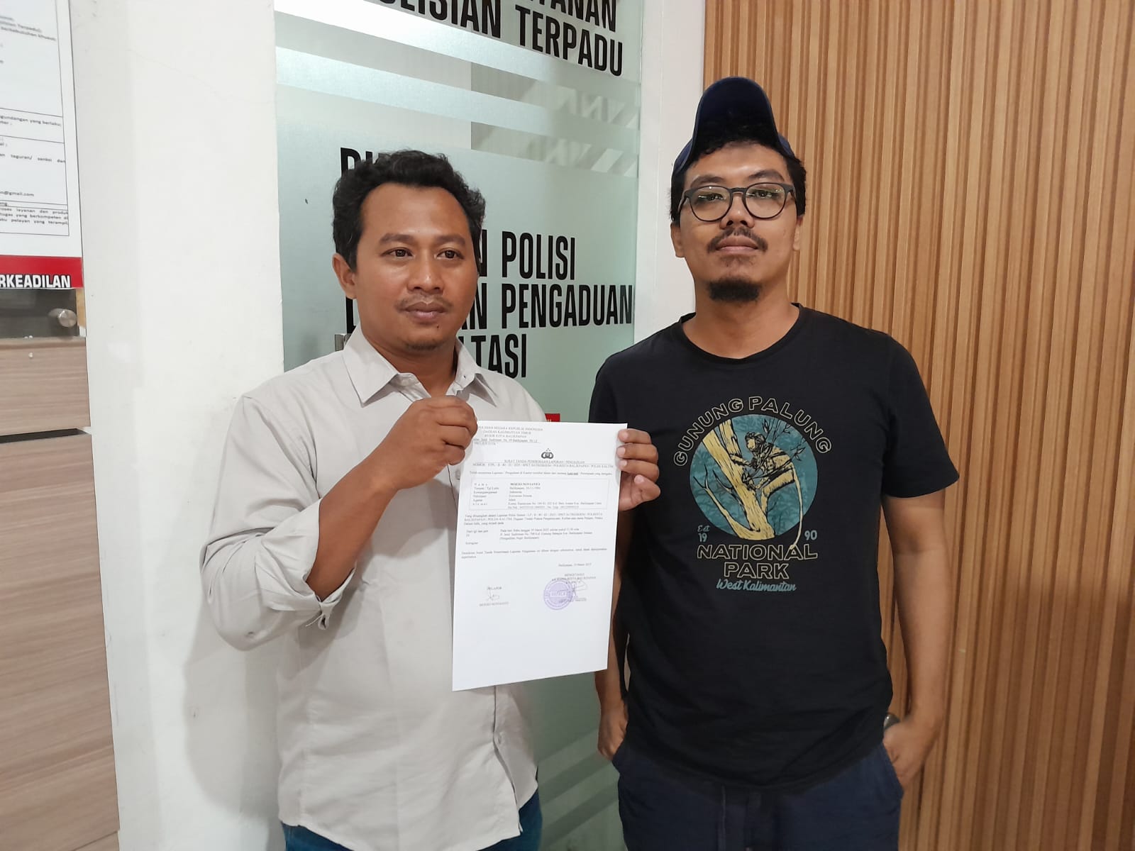 Moeso Novianto (kiri) didampingi Ketua AJI Balikpapan, Erik Alfian saat membuat laporan di SPKT Polresta Balikpapan, Rabu (19/3/2025).