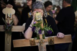 Para peziarah Kristen memegang salib saat prosesi Jumat Agung di Kota Tua Yerusalem. Foto: Léo Corrêa/AP/The Guardian