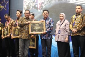 Menteri Dalam Negeri Tito Karnavian menyerahkan Piagam Penghargaan SPM Awards 2025 kepada Asisten Tata Pemerintahan Setda Kota Balikpapan, Zulkinli, / IST