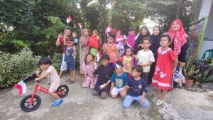 Emak-emak lomba HUT RI di Gala Puncak RT 25, Perumahan Pesona Bukit Batuah, Kelurahan Graha Indah, Balikpapan Utara, Kota Balikpapan, Provinsi Kalimantan Timur. Balon-balon warna-warni tergantung di antara pohon cery dan pagar besi hijau. Dengan mata tertutup kain merah putih, para peserta maju satu per satu, menebak-nebak arah sambil membawa sebatang tusuk bambu. (HO/Gala Puncak)