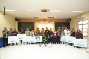 Para penerima manfaat program TJSL Bandara SAMS Sepinggan berfoto bersama manajemen usai penyerahan bantuan di Gedung Serba Guna, Balikpapan.