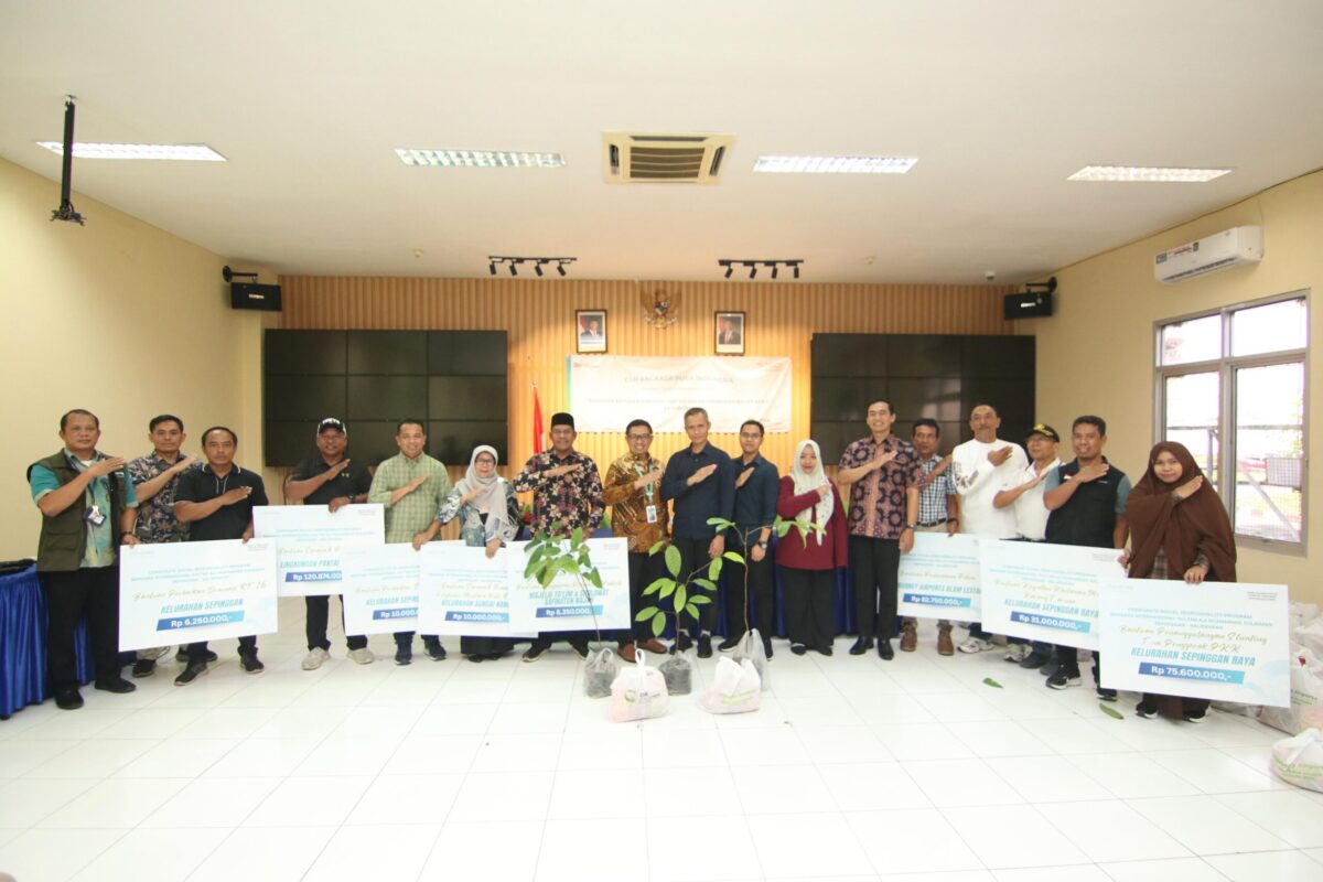 Para penerima manfaat program TJSL Bandara SAMS Sepinggan berfoto bersama manajemen usai penyerahan bantuan di Gedung Serba Guna, Balikpapan.