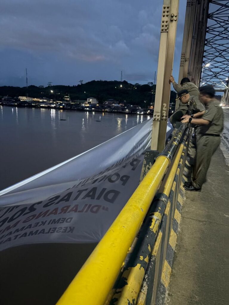Satpol PP Kaltim memasang spanduk larangan melintas di bawah jembatan Mahulu Samarinda / Pemprov