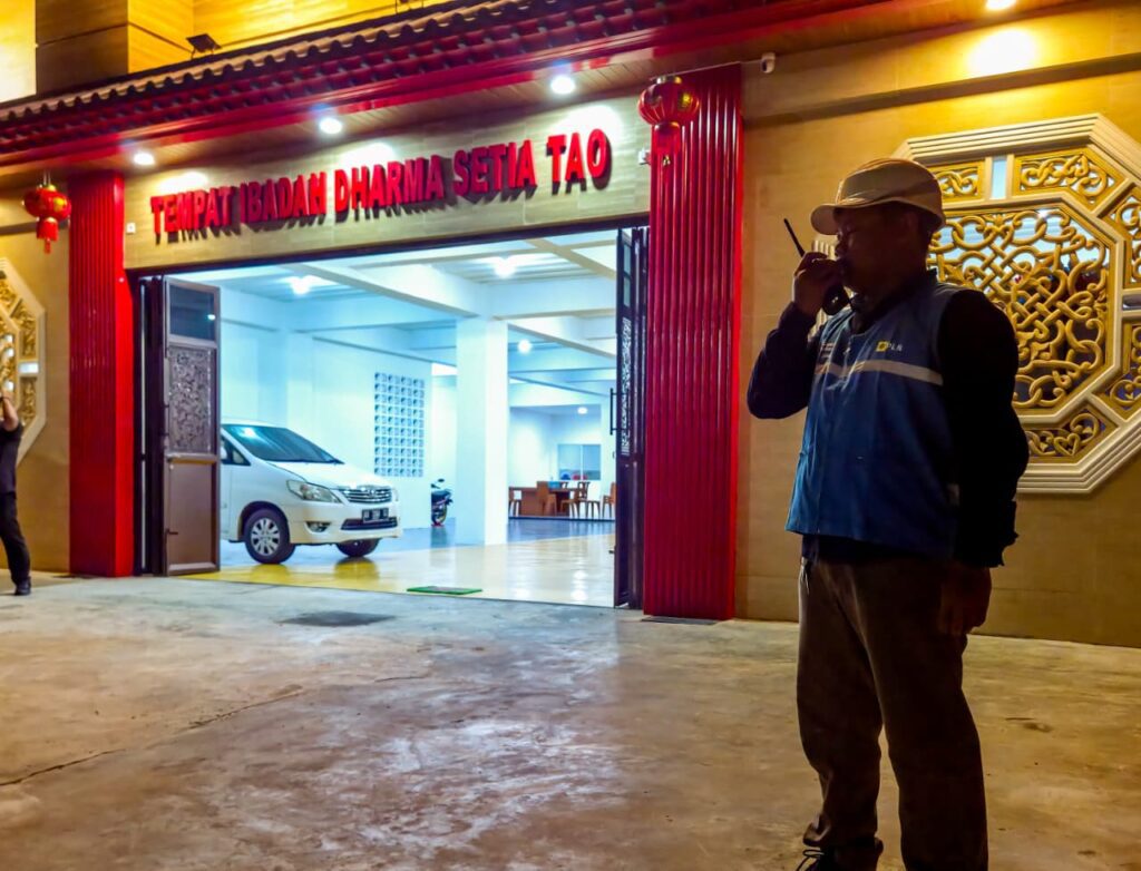 Petugas PLN berjaga di depan Tempat Ibadah Dharma Setia Tao Balikpapan saat perayaan Imlek, memastikan pasokan listrik tetap aman dan andal.