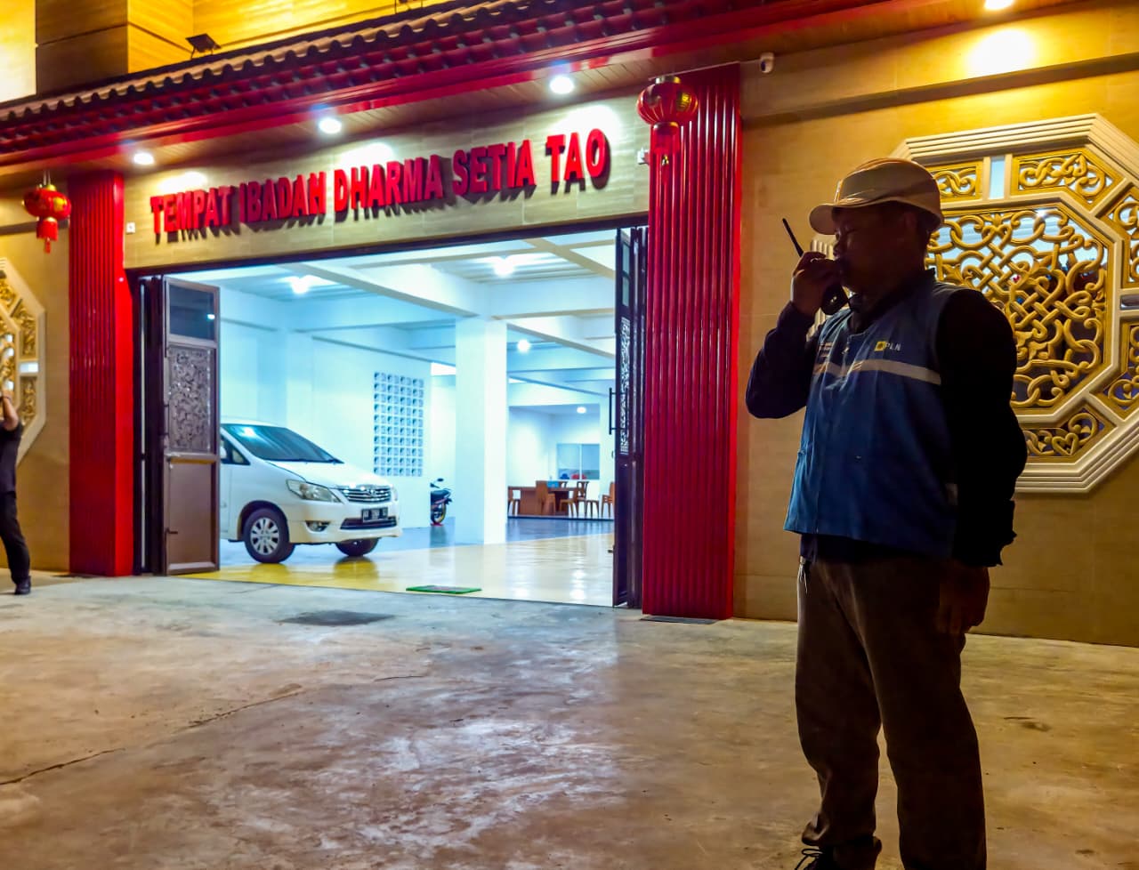 Petugas PLN berjaga di depan Tempat Ibadah Dharma Setia Tao Balikpapan saat perayaan Imlek, memastikan pasokan listrik tetap aman dan andal.