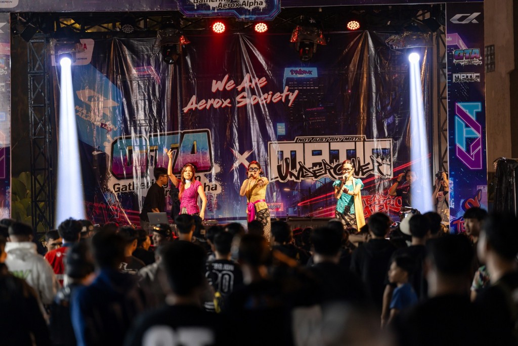 Pengunjung menyaksikan penampilan hiburan 10 Dekade Yamaha pada acara Gathering Team AEROX di Bandung, Jumat (25/4).