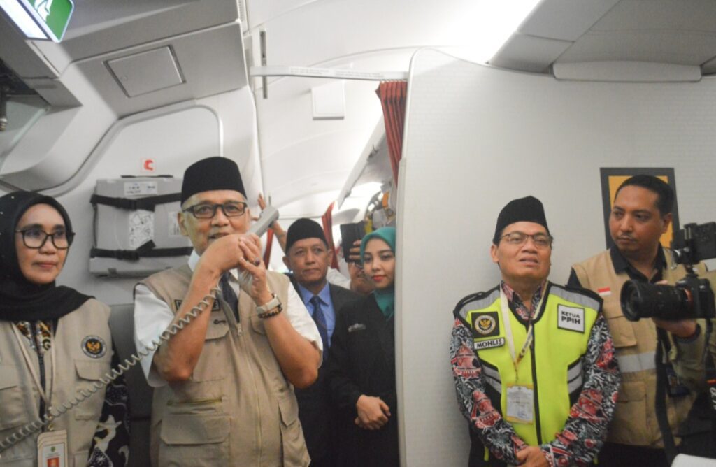 Menteri Haji dan Umrah RI Mochamad Irfan Yusuf menyapa jemaah haji saat pelepasan Kloter 10 Embarkasi Balikpapan di dalam pesawat Garuda Indonesia menuju Jeddah, Minggu (10/5/2026).