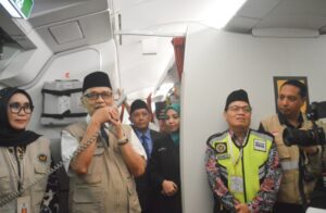 Menteri Haji dan Umrah RI Mochamad Irfan Yusuf menyapa jemaah haji saat pelepasan Kloter 10 Embarkasi Balikpapan di dalam pesawat Garuda Indonesia menuju Jeddah, Minggu (10/5/2026).