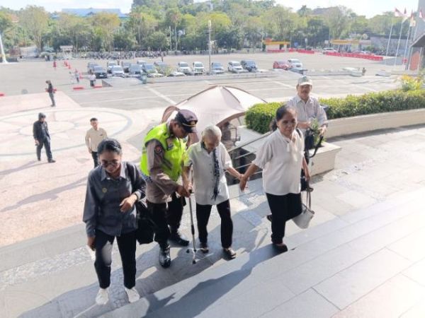Personel Polresta Balikpapan membantu lansia memasuki BSC untuk beribah Kenaikan Isa Almasih (foto : Polresta)