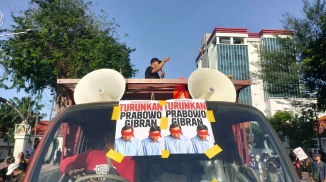 : Aliansi Rakyat Surabaya Menggugat menuntut Presiden Prabowo Subianto dan Wakil Presiden Gibran Rakabuming Raka mundur dari jabatannya dalam aksi demo yang digelar di depan Gedung Grahadi, Senin (22/6/2026). [suara.com/dimas angga]