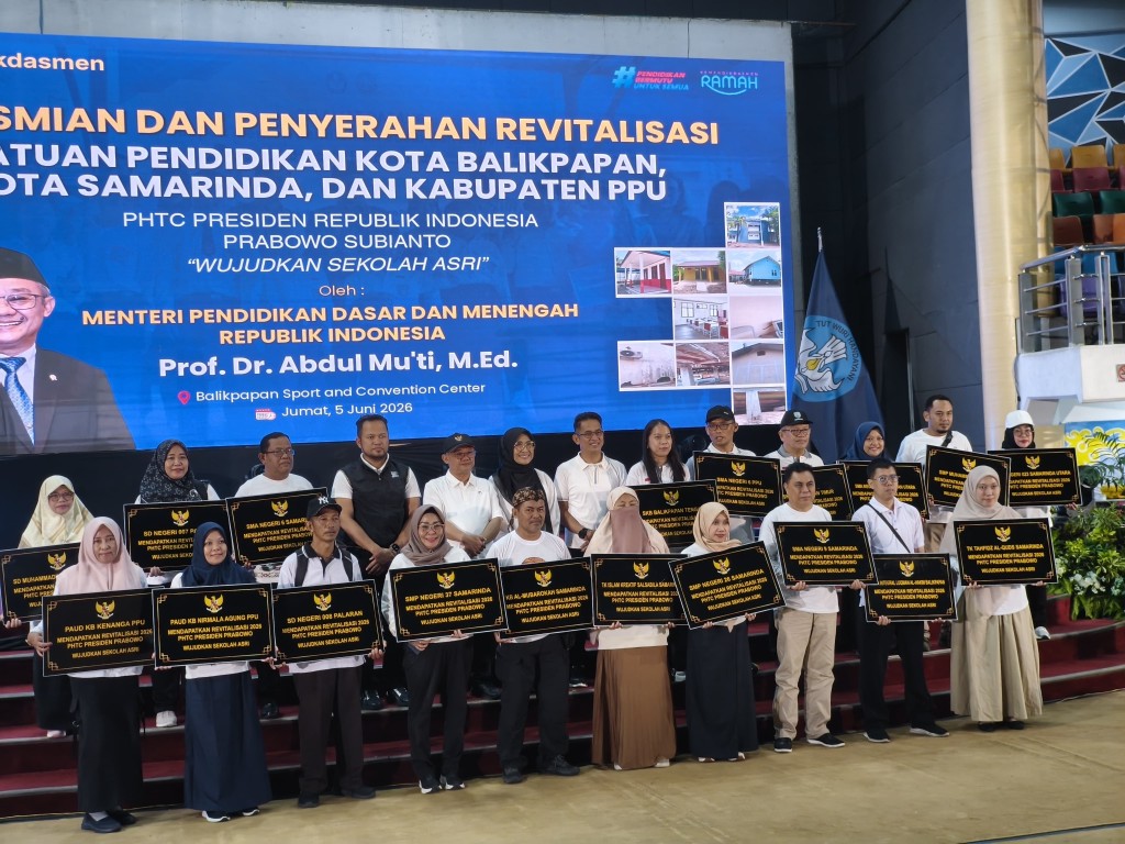 Mendikdasmen Abdul Mu'ti menyerahkan bantuan revitalisasi kepada perwakilan sekolah penerima di BSCC Dome Balikpapan, Jumat (5/6/2026).