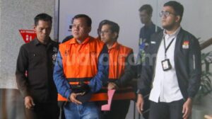 Bupati Kuantan Singingi Suhardiman Amby (tengah) berjalan menuju mobil tahanan usai menjalani pemeriksaan di Gedung Merah Putih KPK, Jakarta, Rabu (1/7/2026). [Suara.com/Alfian Winanto]
