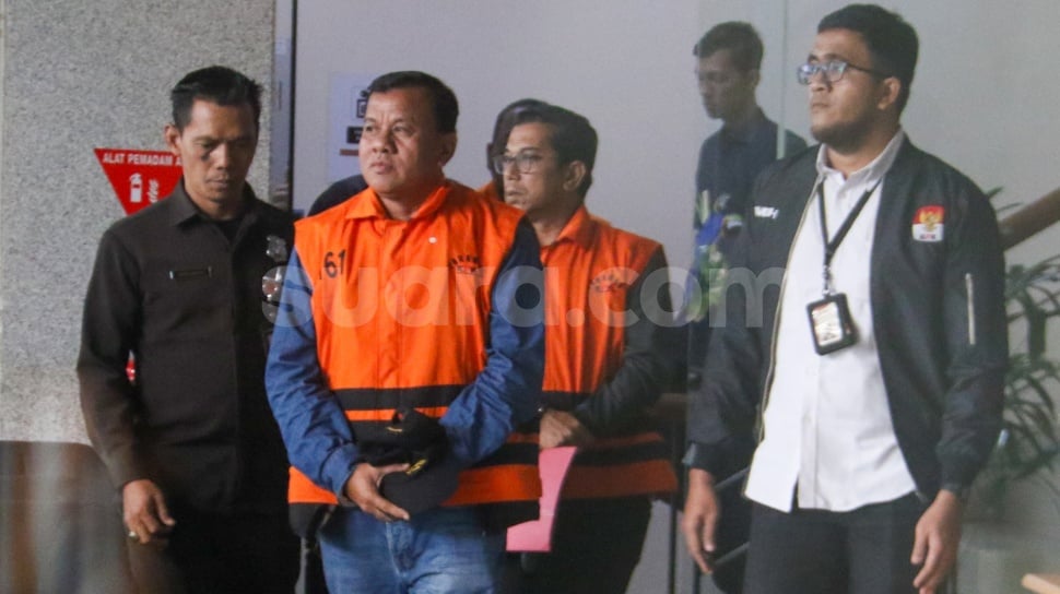 Bupati Kuantan Singingi Suhardiman Amby (tengah) berjalan menuju mobil tahanan usai menjalani pemeriksaan di Gedung Merah Putih KPK, Jakarta, Rabu (1/7/2026). [Suara.com/Alfian Winanto]
