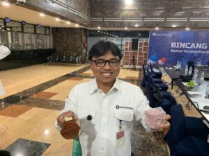 Kepala Kantor Perwakilan BI Balikpapan Robi Ariadi memegang medali dan uang tidak layak edar sebagai bahan pembuatan medali pada event FENTURUN 2026