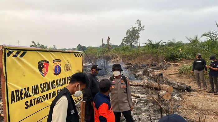 Petugas memasang spanduk peringatan di lokasi yang terindikasi mengalami kebakaran lahan. (foto : Polda Kaltim)