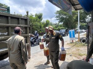 Petugas Satpol PP Balikpapan mengamankan BBM eceran saat operasi penertiban pom mini dan penjualan BBM bersubsidi di salah satu ruas jalan di Balikpapan.