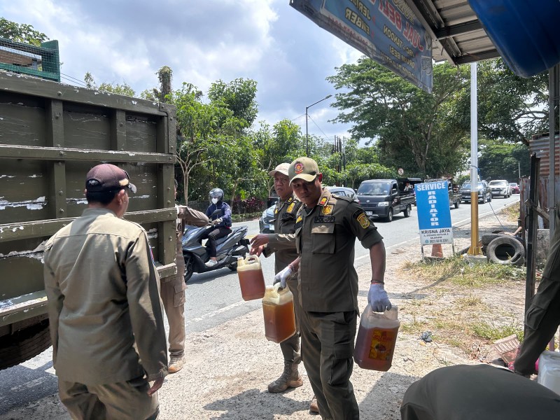 Petugas Satpol PP Balikpapan mengamankan BBM eceran saat operasi penertiban pom mini dan penjualan BBM bersubsidi di salah satu ruas jalan di Balikpapan.